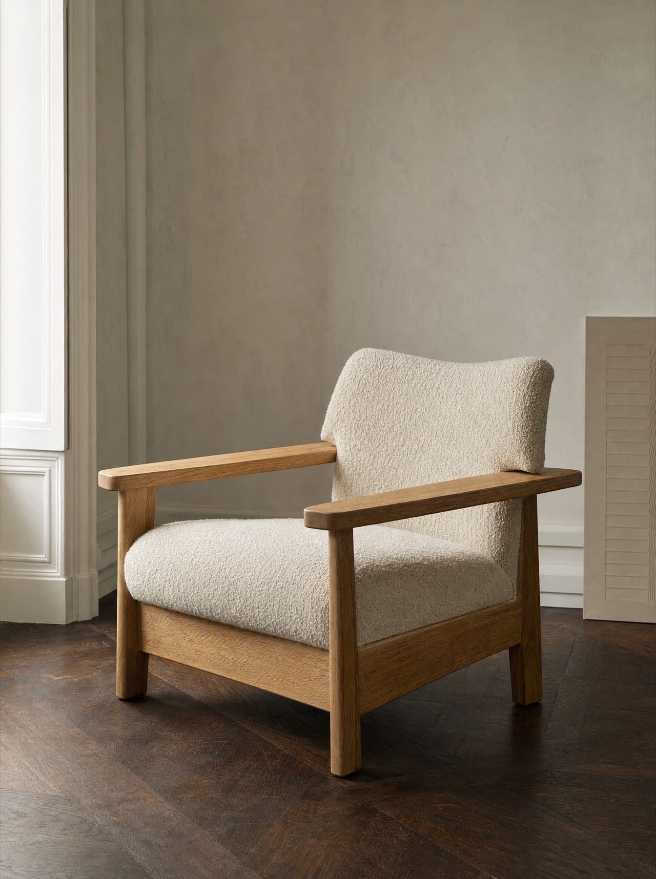 Fauteuil Lubéron à structure de chêne massif apparente et garniture en bouclette écrue, accotoirs plats, vue de trois quarts