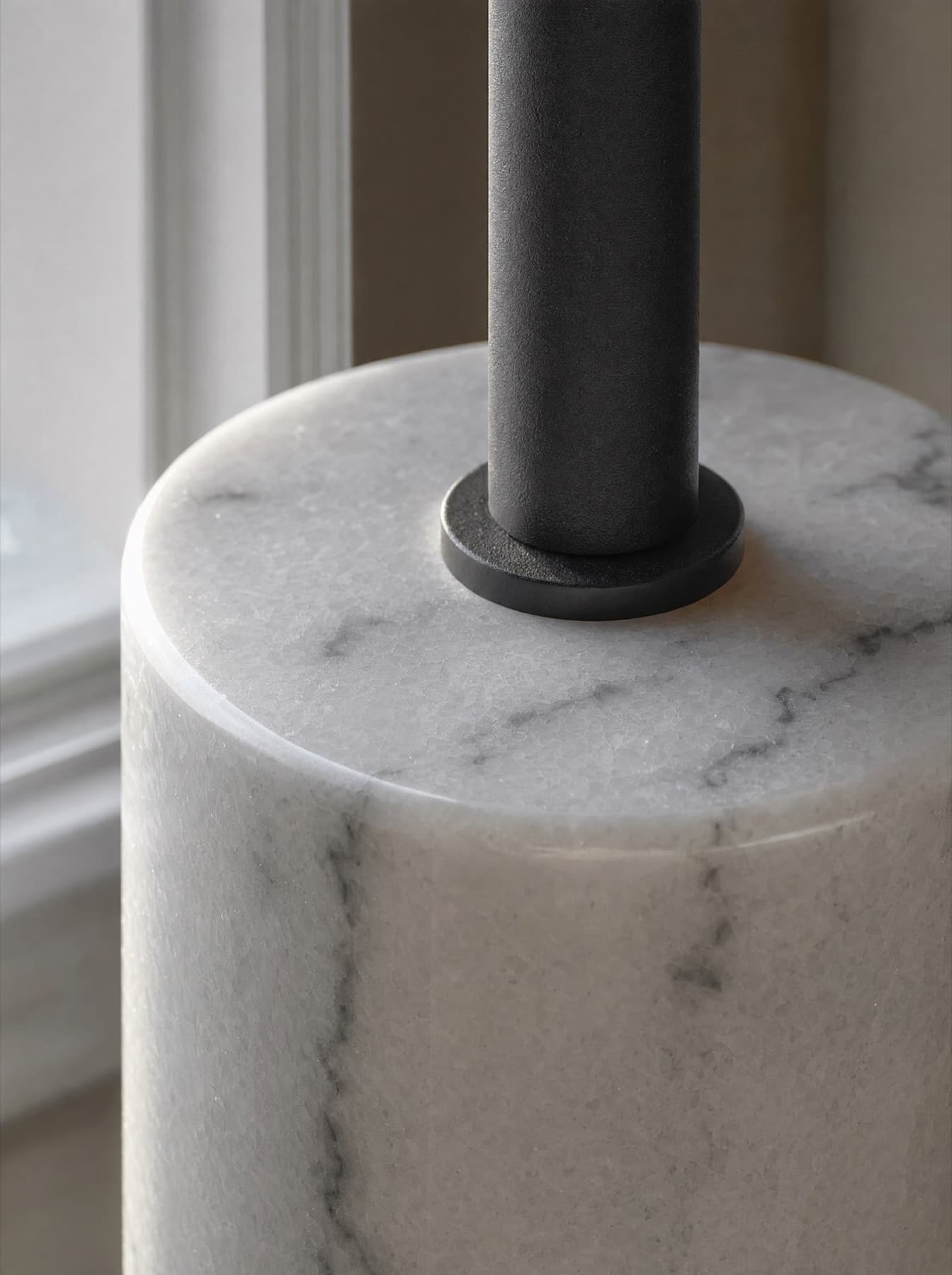 Détail du lampadaire Vercors : l’emmanchement de la tige d’acier dans la base cylindrique en marbre, veinage et collerette usinée